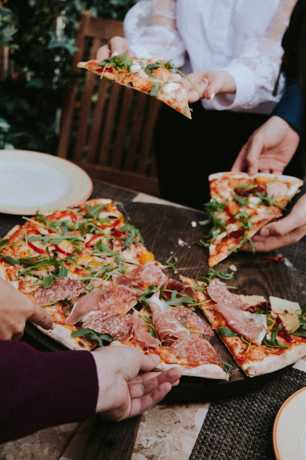 Amici che dividono una pizza